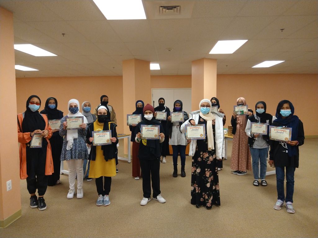 Proud Hidayah Academy graduates holding acceptance letters from top universities like George Washington University, George Mason University, and Penn State.